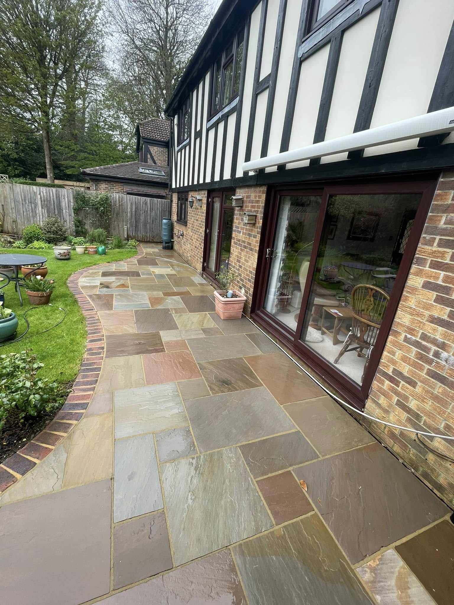 Immaculately clean Indian Sandstone patio along a luxury Tudor-style home showcase